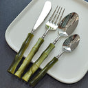 Talheres de inox com cabo em resina bambu sobre prato branco, conjunto premium para mesa posta sofisticada.
