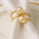 Anel de guardanapo com pérola Casa Splendida em versão dourada sobre louça branca e acabamento sofisticado