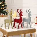 “Renas Decorativas de Natal Casa Splendida em posição ereta sobre uma mesa em madeira nas cores vermelho, prata e dourado.