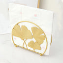 Porta‑guardanapos metálico dourado com folhas de ginkgo