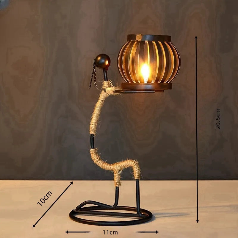 Castiçal escultura em ferro com figura abstrata e porta‑vela em forma de gaiola