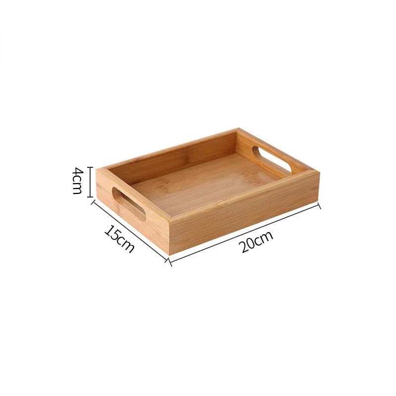 Bandeja retangular de bambu natural com alças vazadas laterais sobre mesa de madeira, ideal para servir e organizar

