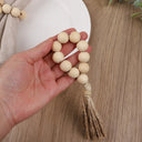 Porta-guardanapo artesanal com contas de madeira natural e tassel de juta – estilo boho e rústico para mesa posta elegante.

