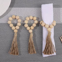 Porta-guardanapo artesanal com contas de madeira natural e tassel de juta – estilo boho e rústico para mesa posta elegante.

