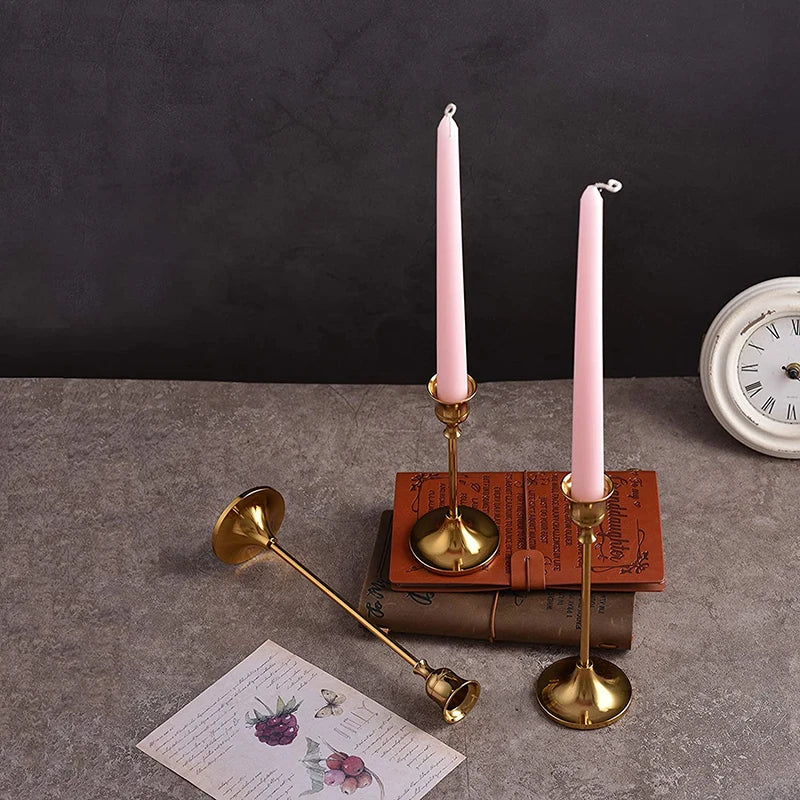 Kit 3 castiçais vintage dourados em alturas diferentes sobre mesa decorada”