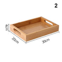 Bandeja retangular de bambu natural com alças vazadas laterais sobre mesa de madeira, ideal para servir e organizar


