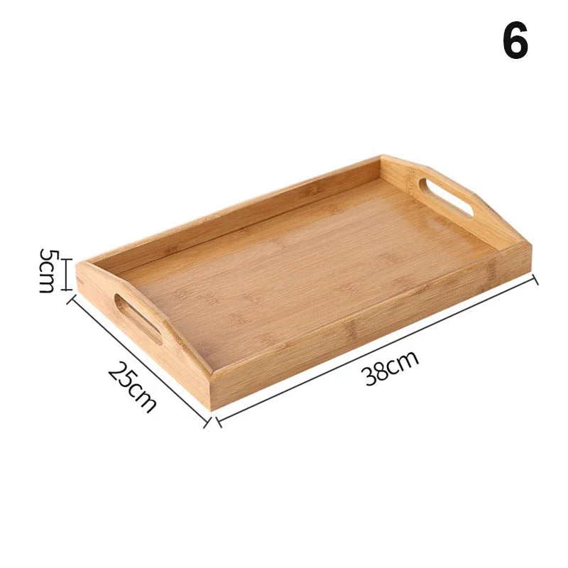 Bandeja retangular de bambu natural com alças vazadas laterais sobre mesa de madeira, ideal para servir e organizar

