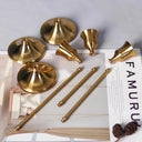 Kit 3 castiçais vintage dourados em alturas diferentes sobre mesa decorada”