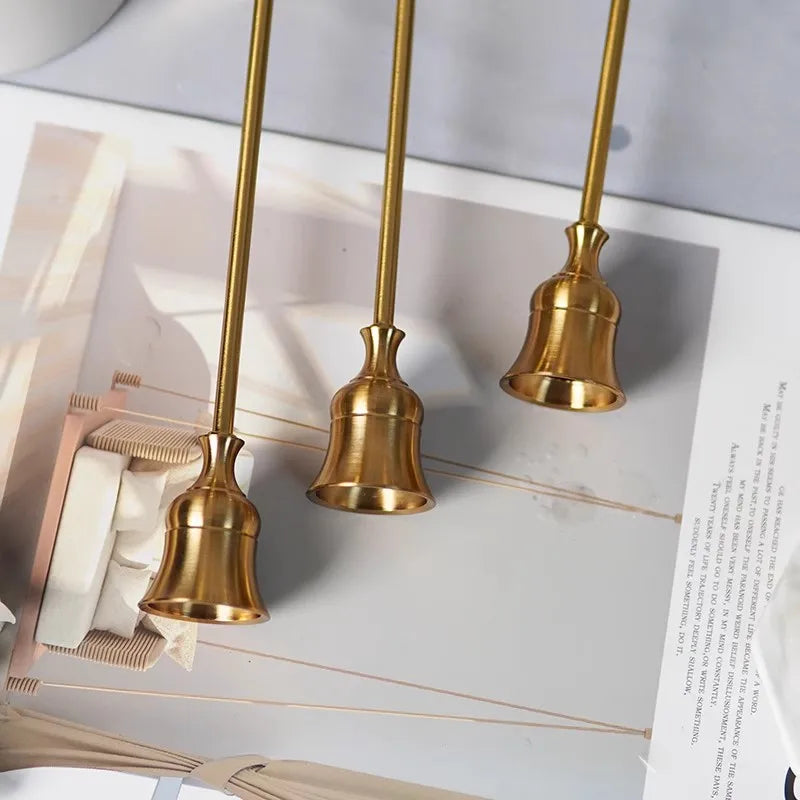 Kit 3 castiçais vintage dourados em alturas diferentes sobre mesa decorada”
