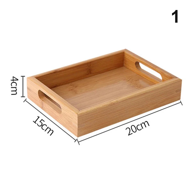 Bandeja retangular de bambu natural com alças vazadas laterais sobre mesa de madeira, ideal para servir e organizar

