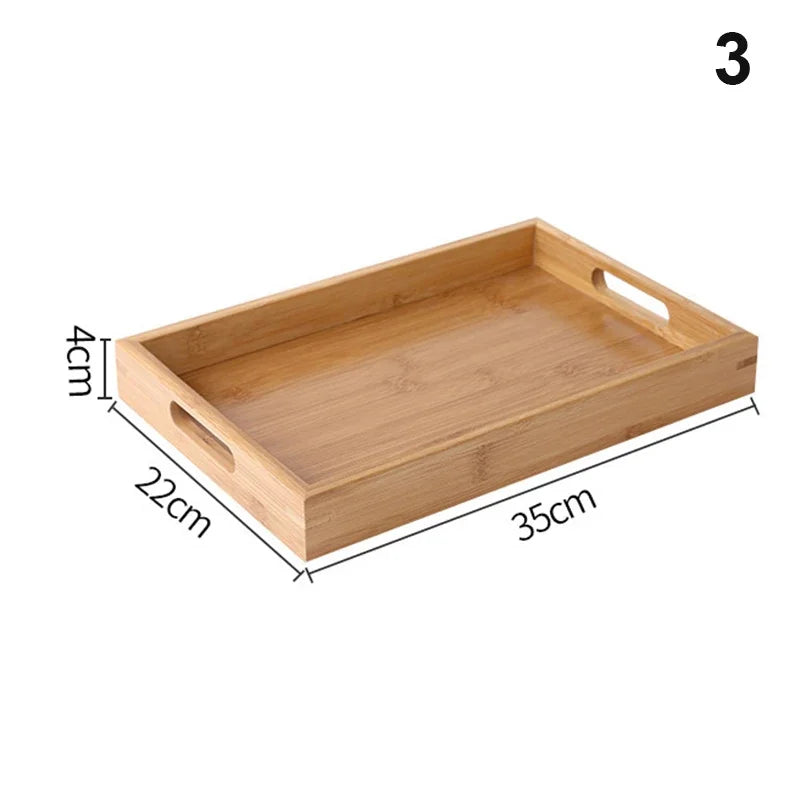 Bandeja retangular de bambu natural com alças vazadas laterais sobre mesa de madeira, ideal para servir e organizar

