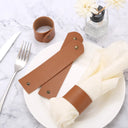 Porta‑guardanapo de couro marrom com rebite metálico em mesa posta estilo farmhouse, conjunto com guardanapos claros