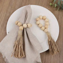 Porta-guardanapo artesanal com contas de madeira natural e tassel de juta – estilo boho e rústico para mesa posta elegante.

