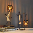 Castiçal escultura em ferro com figura abstrata e porta‑vela em forma de gaiola