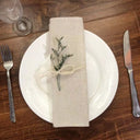 Guardanapo de linho bege em mesa posta elegante com prato decorado