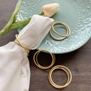 Porta‑guardanapo de metal dourado minimalista, anel duplo em mesa posta – Casa Splendida.

