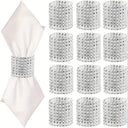 Conjunto de 12 porta-guardanapos cilíndricos pratas em PP com brilho envolvendo guardanapo branco em mesa posta – Casa Splendida.

