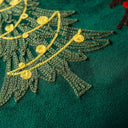 Detalhe do bordado dourado da árvore de Natal sobre veludo verde — Casa Splendida
